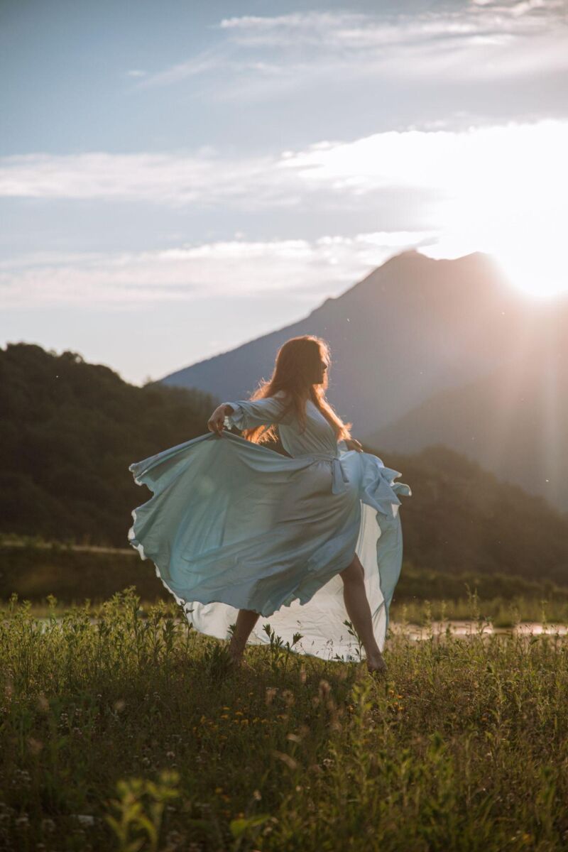 bride jumping in the field happy with the wedding dress